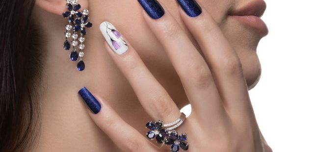 woman-with-nail-art-promoting-design-luxury-earrings-ring
